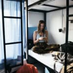 Alleinreisende Frau in einem Hostelzimmer
