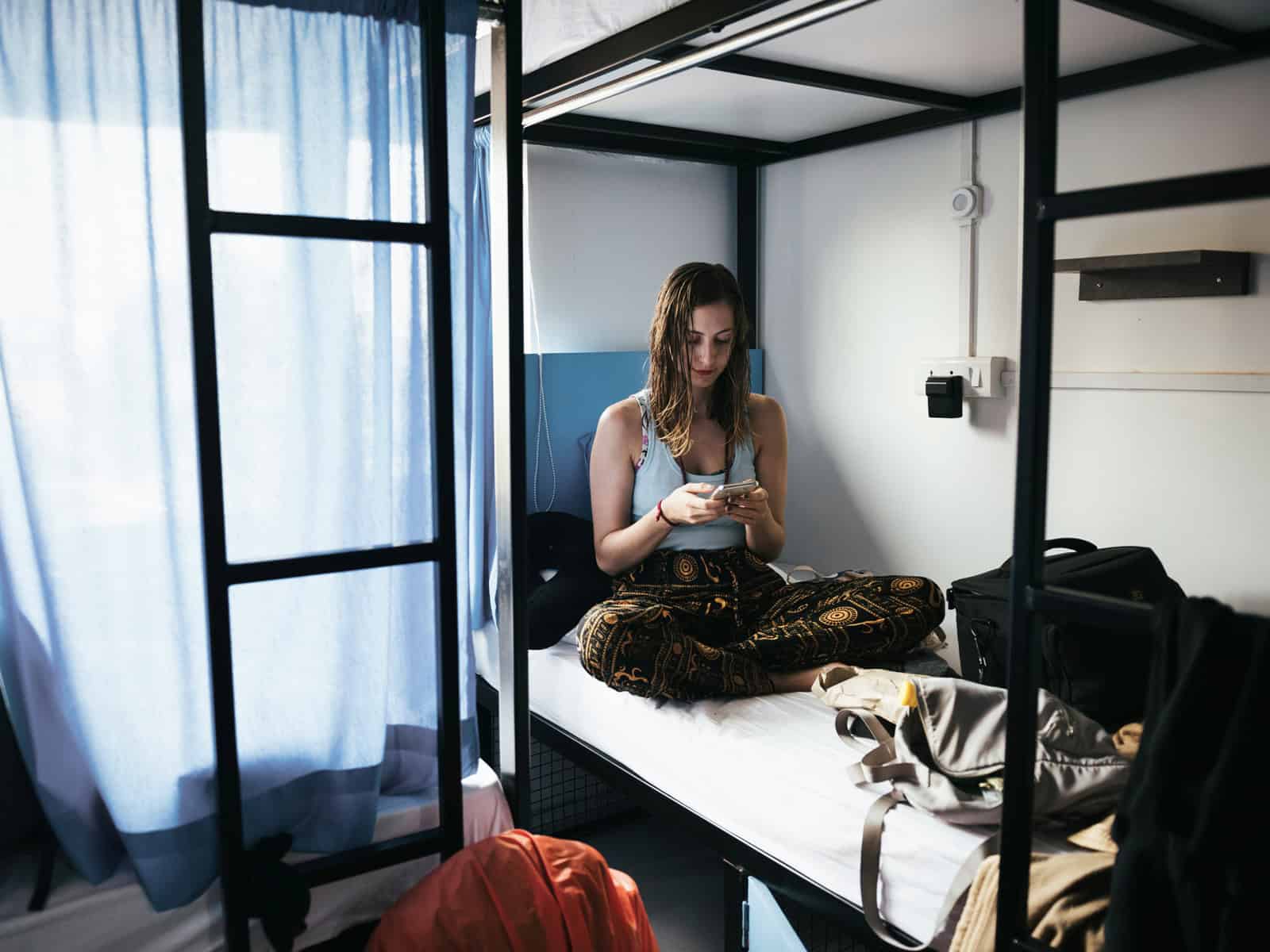Alleinreisende Frau in einem Hostelzimmer