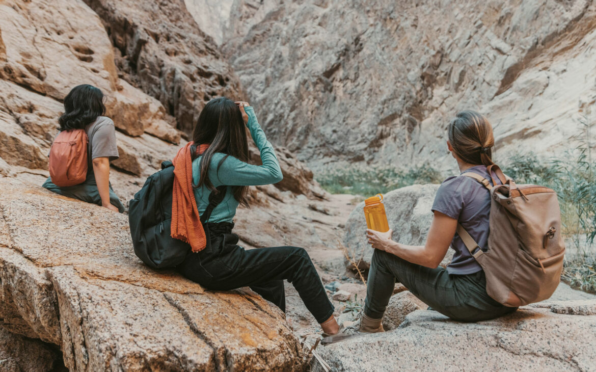Als Alleinreisende sind drei Frauen auf einer gemeinsamen Wanderung durch eine felsige Schlucht